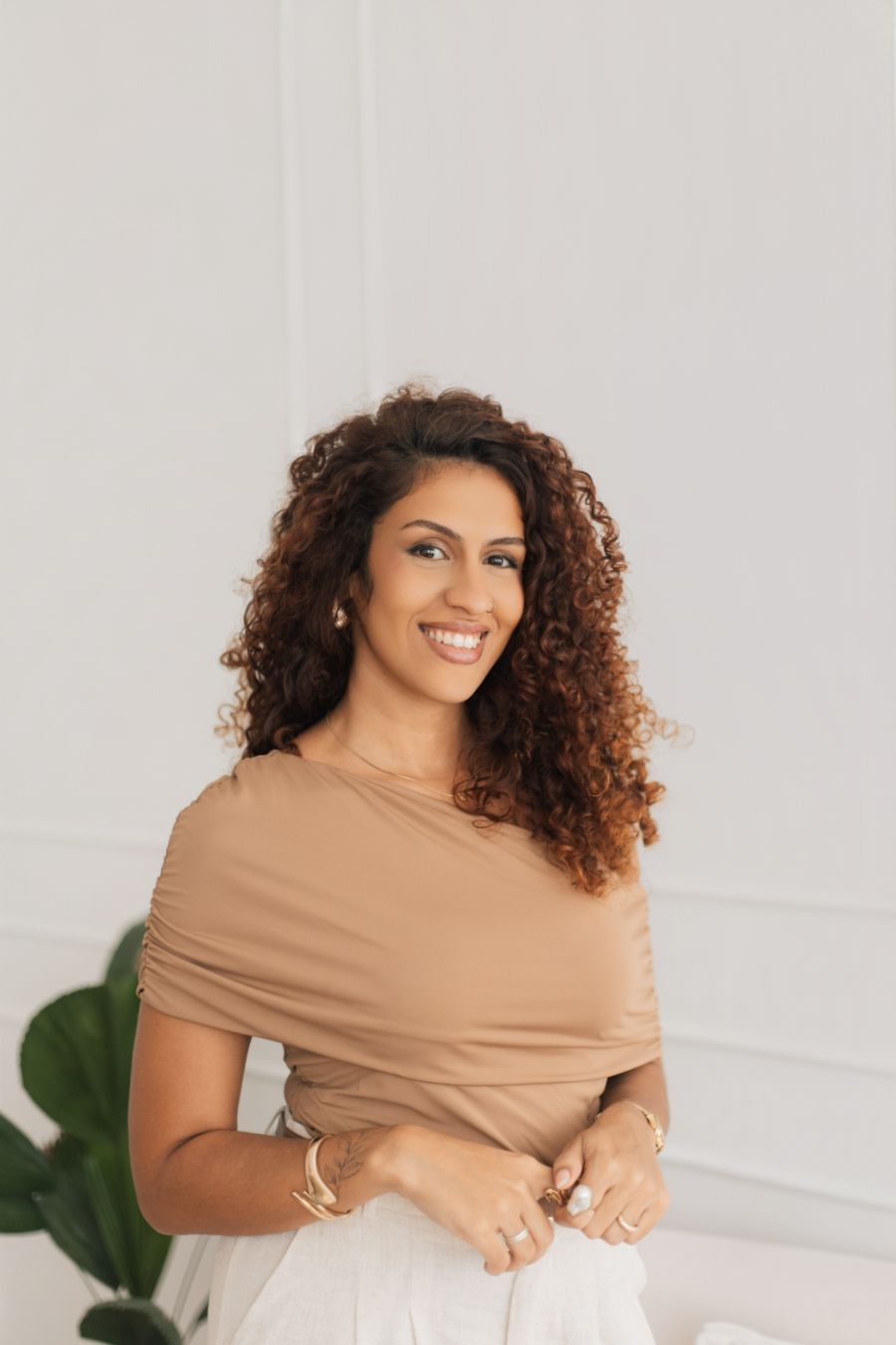Retrato de Aline Valente, sorrindo, de blusa caramelo